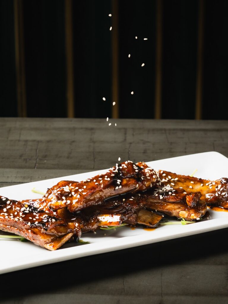 Glazed lamb ribs finished with sesame at The Ivy Steakhouse