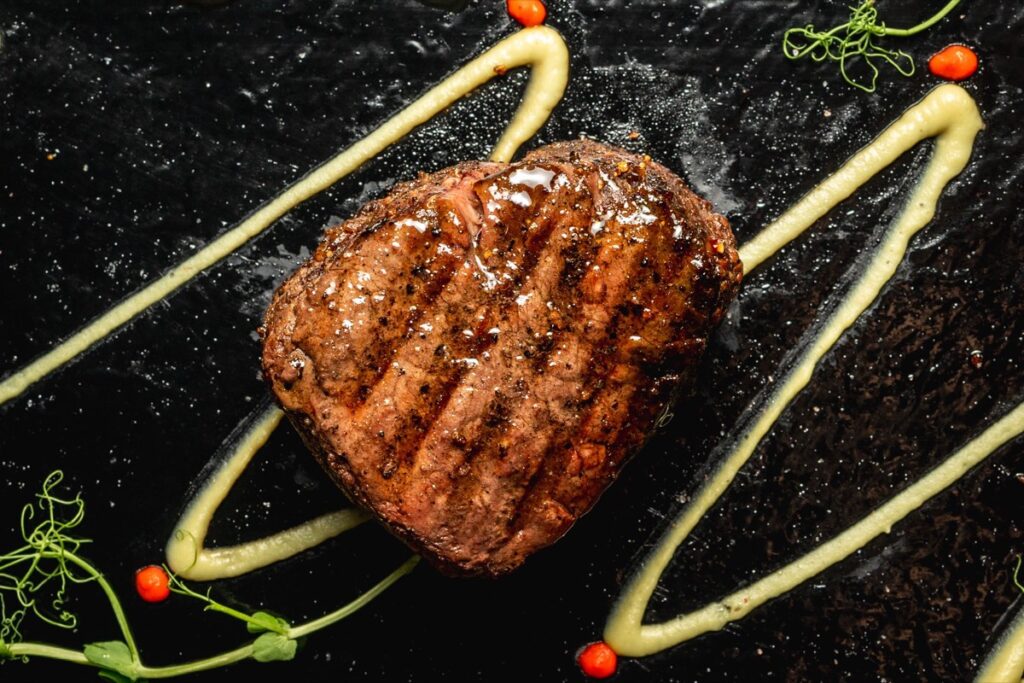 A grilled feature steak on slate, finished with sauce